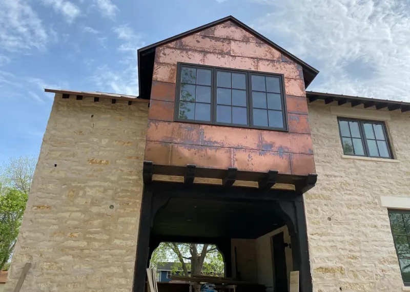 Copper metal panel facade on a stone building for Roof Repair in Friendswood